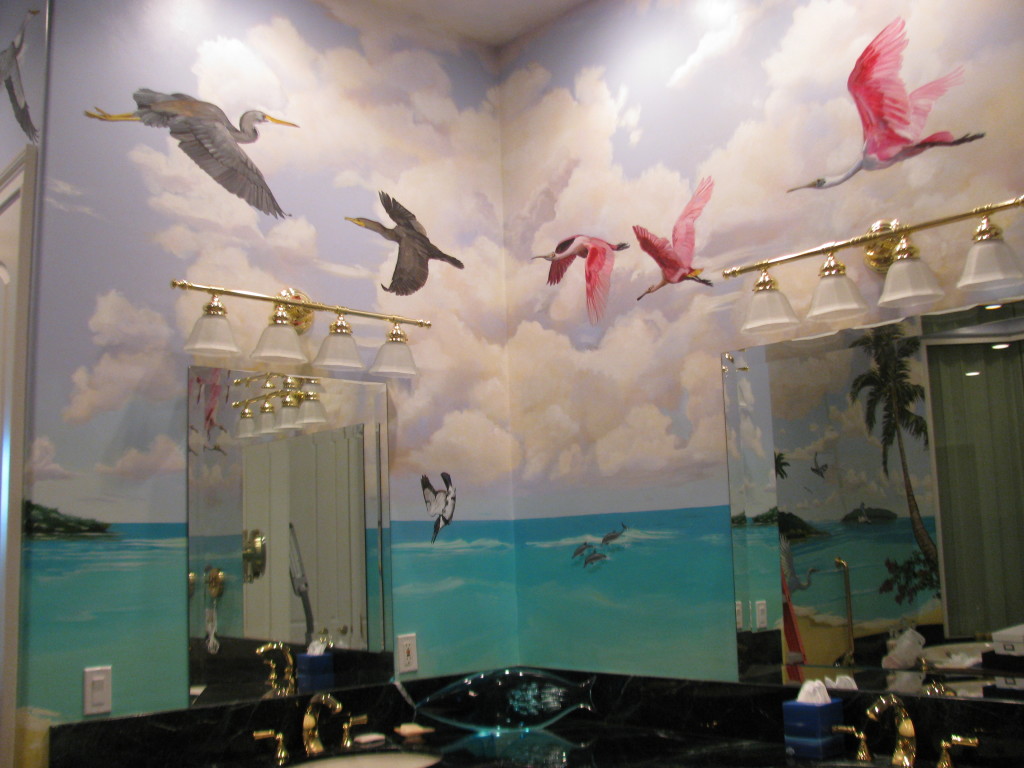 Hand Painted Custom Murals. a masterbath vanity area showing a mural of blue sky, aqua water, and florida birds flying overhead.