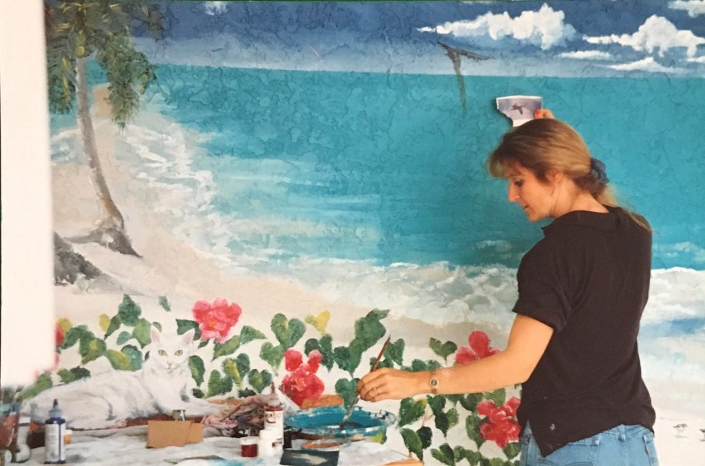 Martha painting an outdoor poolside mural in the 90's.