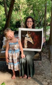 aubrey veally and her daughter holding the print of the giraffe