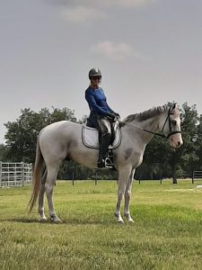 Martha Dodd sitting on a white horse named Wiley