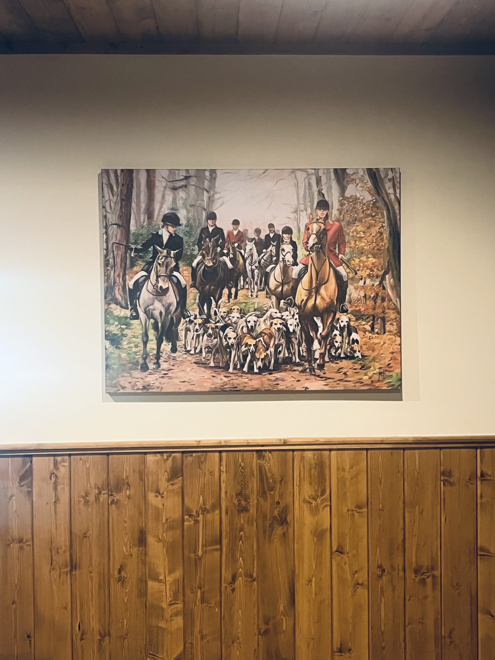 a wall with a painting of foxhunters.